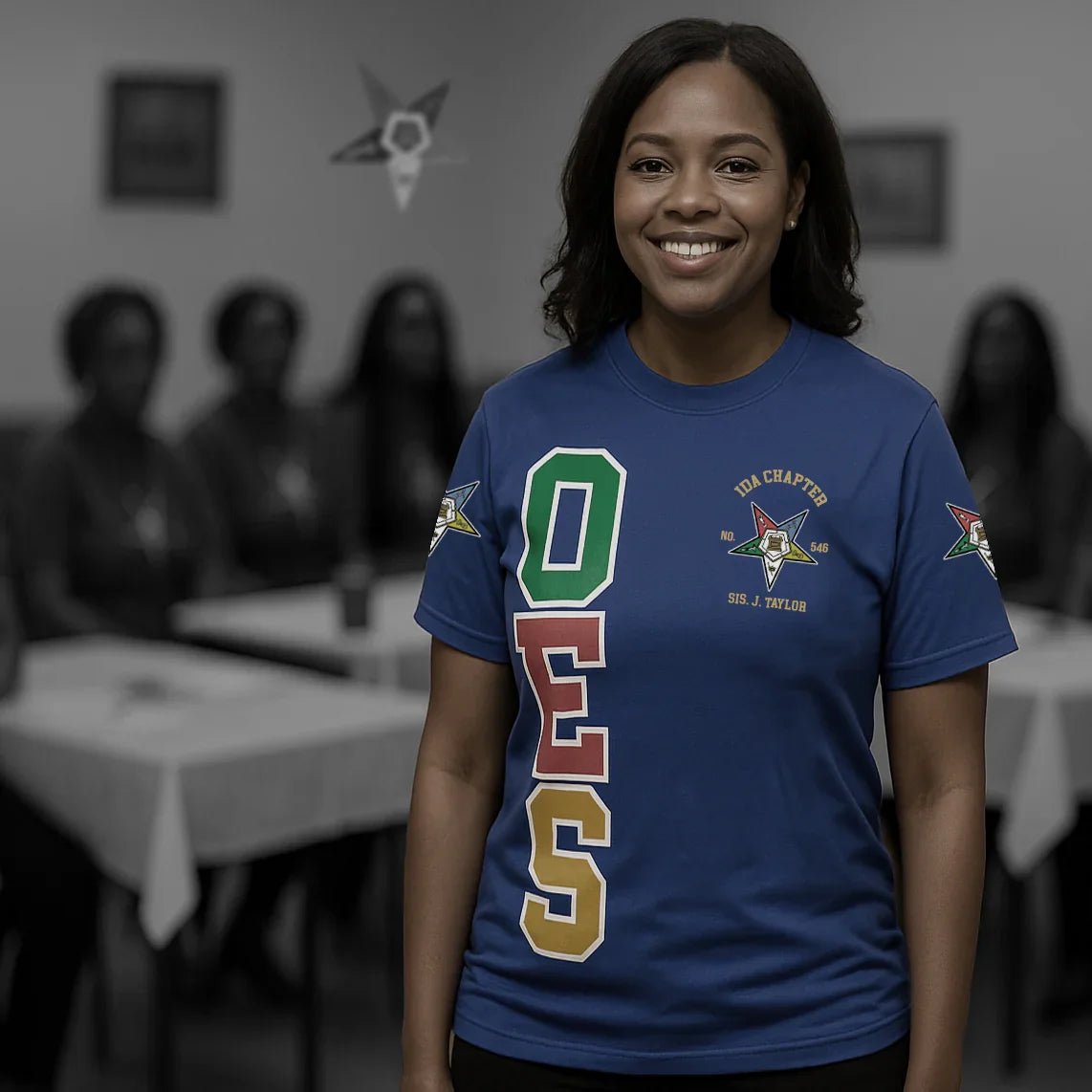 Person wearing a blue t-shirt with colorful letters in a room