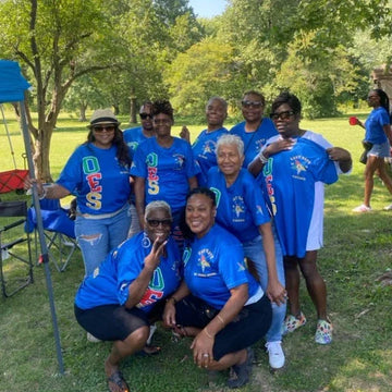 Group of people wearing blue shirts with a logo and text, standing outdoors